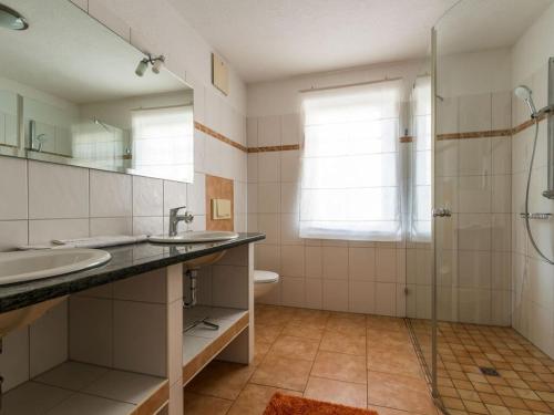 ein Bad mit 2 Waschbecken und einer Dusche in der Unterkunft Holiday apartment coastal love in Wustrow
