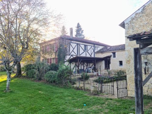 an old house with a fence in front of a yard at Gîte Les papillons 4 étoiles in Gondrin