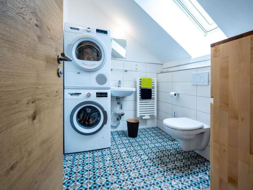 a bathroom with a washing machine and a toilet at Holiday apartment Forsthaus Heilsberg in Wiesent