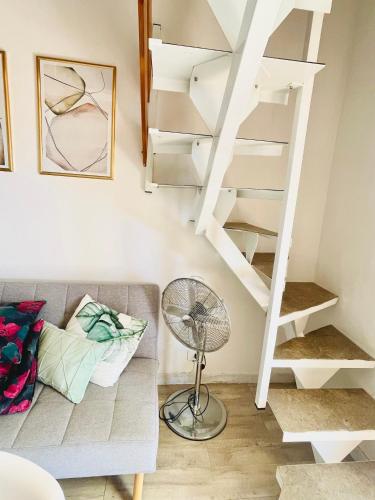 sala de estar con sofá y escalera de caracol en Lovely Turano, en Valle Verde