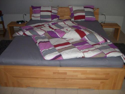 uma cama com uma estrutura de madeira com um cobertor em Seegarden on the Kastanienhof em Pellworm