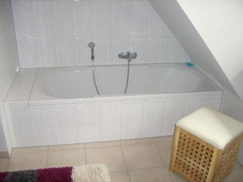 uma banheira branca com uma mangueira na casa de banho em Seegarden on the Kastanienhof em Pellworm