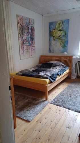 胡爾特的住宿－Galerie in Hürth，墙上画作的房间的一张床位