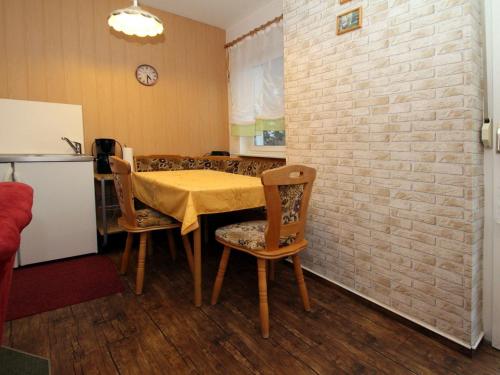 una cucina con tavolo, sedie e muro di mattoni di Apartments Spreewaldperle Alt Zauche a Alt Zauche