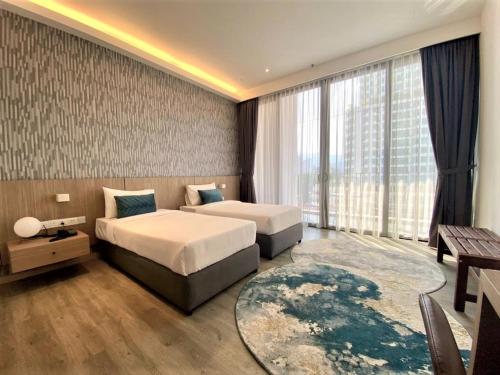 a bedroom with two beds and a large window at Corner Club Penang in George Town
