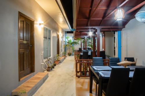 烏庫哈斯的住宿－Palm Oasis at Ukulhas，一间带桌椅的餐厅以及种植了植物的走廊