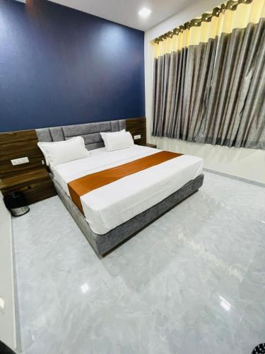 a bedroom with a bed and a blue wall at Hotel Nova Blue in Ahmedabad