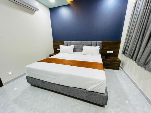 a bedroom with a large bed in a room at Hotel Nova Blue in Ahmedabad