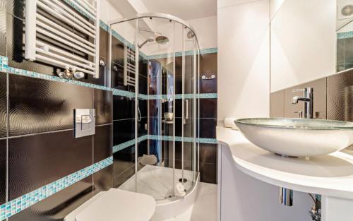 a bathroom with a sink and a glass shower at Wonder Home - Apartamenty z widokiem na góry, blisko stoków narciarskich i szlaków turystycznych in Karpacz
