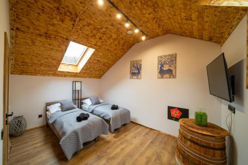Barcice的住宿－Czarni Górale，配有木天花板的客房内的两张床