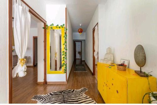 a living room with a yellow dresser and a hallway at Chez Moi Orange Room in El Campello