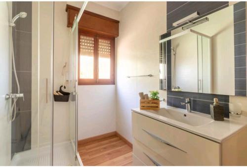 a bathroom with a sink and a shower with a mirror at Chez Moi Orange Room in El Campello