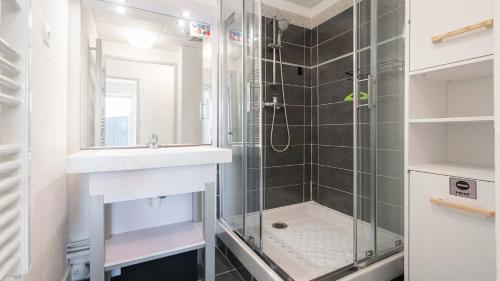La salle de bains est pourvue d'une douche en verre et d'un lavabo. dans l'établissement CAP CAMARGUE - B28- Appt 4 pers- lumineux, au Grau-du-Roi