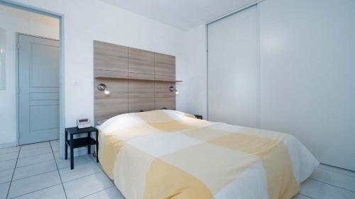 - une chambre avec un grand lit et une tête de lit en bois dans l'établissement CAP CAMARGUE - B28- Appt 4 pers- lumineux, au Grau-du-Roi
