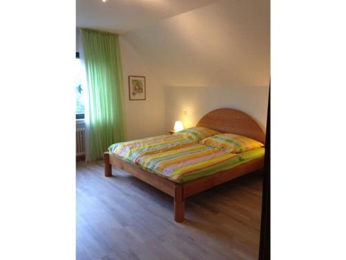 een slaapkamer met een bed en een groen gordijn bij Holiday apartment Xantener Aue in Xanten