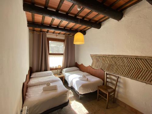 a room with two beds and a window at Yeguada Senillosa - Turismo Rural in Castelló d'Empúries