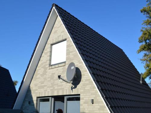 a house with a gambrel roof with a window at Holiday home Tim Paul in Hoddersdeich