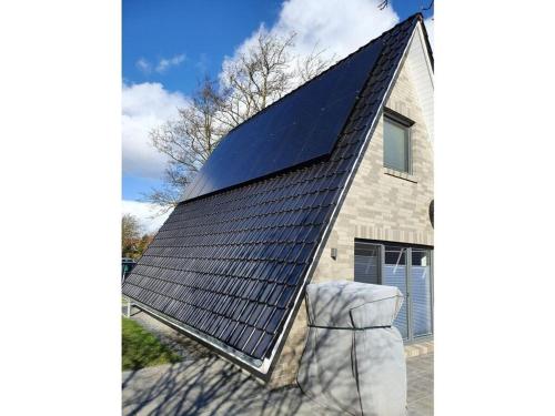 a house with a solar roof on top of it at Holiday home Tim Paul in Hoddersdeich