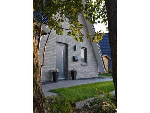 a white brick house with a door on the side at Holiday home Tim Paul in Hoddersdeich