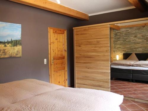een slaapkamer met een bed en een houten muur bij Holiday apartment in Annaberg-Buchholz