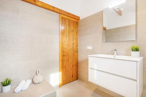 een badkamer met een wastafel en een spiegel bij MISTRAL 2 in Fornells