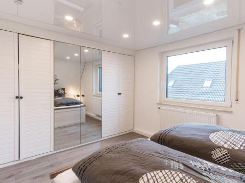 2 Betten in einem Schlafzimmer mit einem großen Fenster in der Unterkunft Casa del Maiwaldo in Spieka-Neufeld