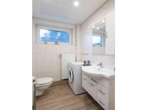 ein weißes Bad mit einem WC und einem Waschbecken in der Unterkunft Casa del Maiwaldo in Spieka-Neufeld