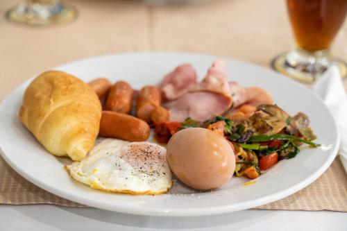 a plate of breakfast food with eggs sausage and vegetables at Four Seasons Hotel in Athens