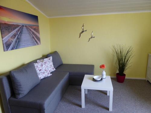 a living room with a couch and a table at Lovely Holiday Home in Bastorf Germany with Garden in Zweedorf