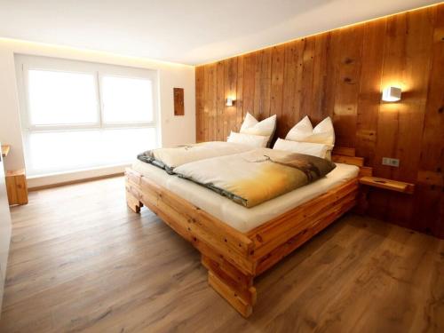 ein Schlafzimmer mit einem Bett mit einer Holzwand in der Unterkunft Holiday apartment Holzwieb in Unterkirnach