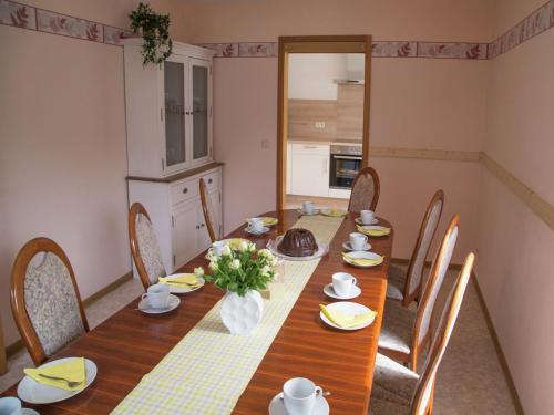 a dining room with a wooden table and chairs at Spacious Holiday Home in Ulmen near the centre in Ulmen