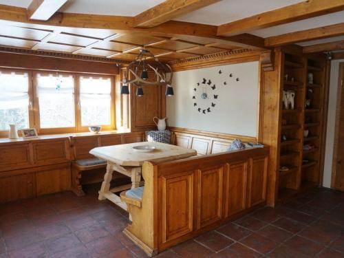 uma cozinha com uma mesa de madeira num quarto em Apartment in the Waxenegg country house em Sulzberg