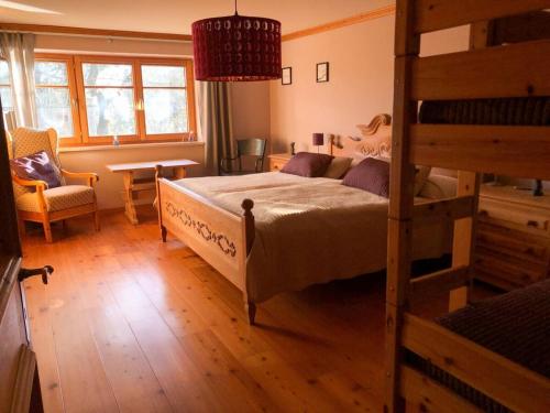 - une chambre avec des lits superposés et une chaise dans l'établissement Apartment in the Waxenegg country house, à Sulzberg