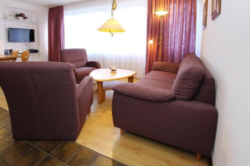 - un salon avec un canapé, une chaise et une table dans l'établissement Apartment in Westerland, à Westerland