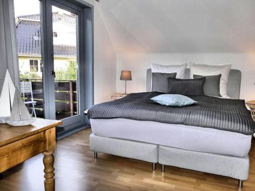 a bedroom with a large bed and a large window at Holiday apartment Green House in Aumühle
