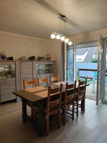 une salle à manger avec une table et des chaises en bois dans l'établissement CHEZ ISA - Maison à 2 km de la plage de Le Portel 62, à Outreau
