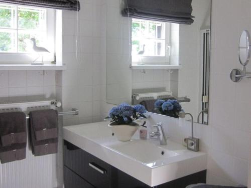 een witte badkamer met een wastafel en een spiegel bij Holiday Apartment Garden Suite in Höchenschwand