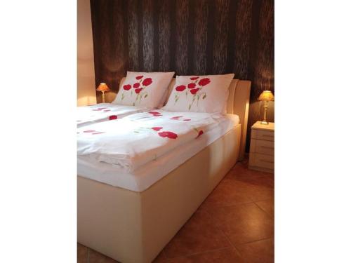 Pleasant apartment in Schwielowsee في شيلووسي: سرير ابيض وعليه ورد احمر في الغرفه