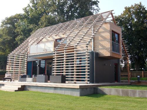 una pequeña casa con techo de madera en un campo en Chalet Wendorf, en Wendorf