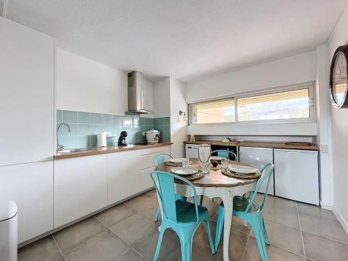 une cuisine avec une table et des chaises dans une pièce dans l'établissement 3287-Appartement 5 couchages à 300m de la plage, à Argelès-sur-Mer