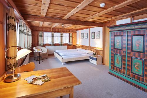 ein Schlafzimmer mit einem Bett und einem Tisch in einem Zimmer in der Unterkunft Hotel Appenberg in Zäziwil