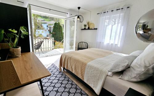 - une chambre avec un lit et une porte donnant sur une terrasse dans l'établissement Ferienwohnungen Krüger 'Apartment Marina', à Gammelsbach