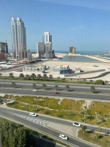 a highway with cars and buildings in a city at Cozy Lovely Apartment in Manama