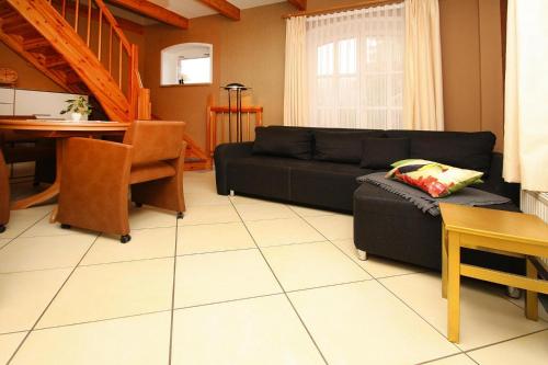 ein Wohnzimmer mit einem schwarzen Sofa und einem Tisch in der Unterkunft Holiday home Plau am See in Plau am See