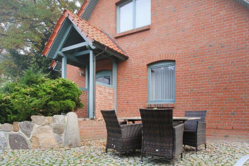 een tafel en stoelen voor een bakstenen gebouw bij Holiday home Plau am See in Plau am See
