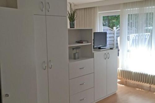 a living room with white cabinets and a television at Apartment in Westerland in Westerland (Sylt)