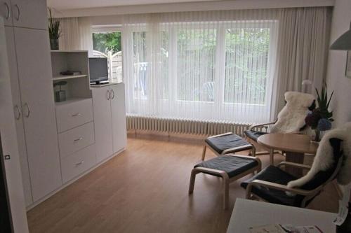 a living room with a table and two chairs and a room with a tablektop at Apartment in Westerland in Westerland (Sylt)
