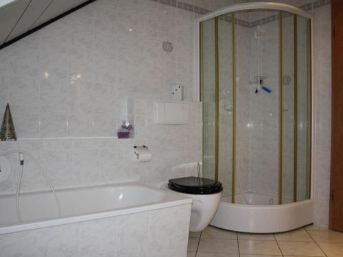 uma casa de banho com uma banheira, um WC e um chuveiro em Holiday apartment Weipert em Ehrenberg