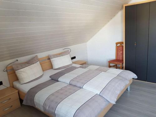 1 dormitorio con 1 cama grande y 1 silla en Holiday apartment Weipert en Ehrenberg