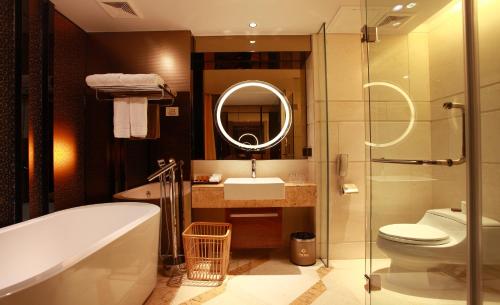 uma casa de banho com uma banheira, um lavatório e um WC. em Hotel Fortune em Shunde